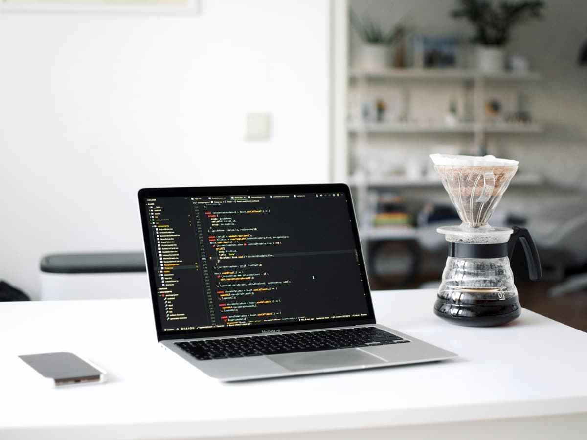 Laptop with code next to coffee, representing website development